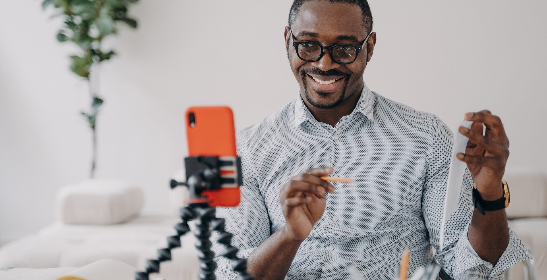 smiling african american businessman presenting business data online by video call, using smartphone