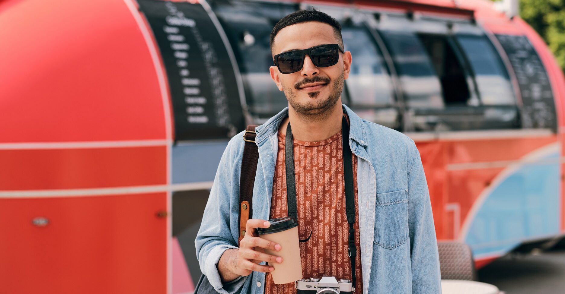 young male photographer with drink and photocamera
