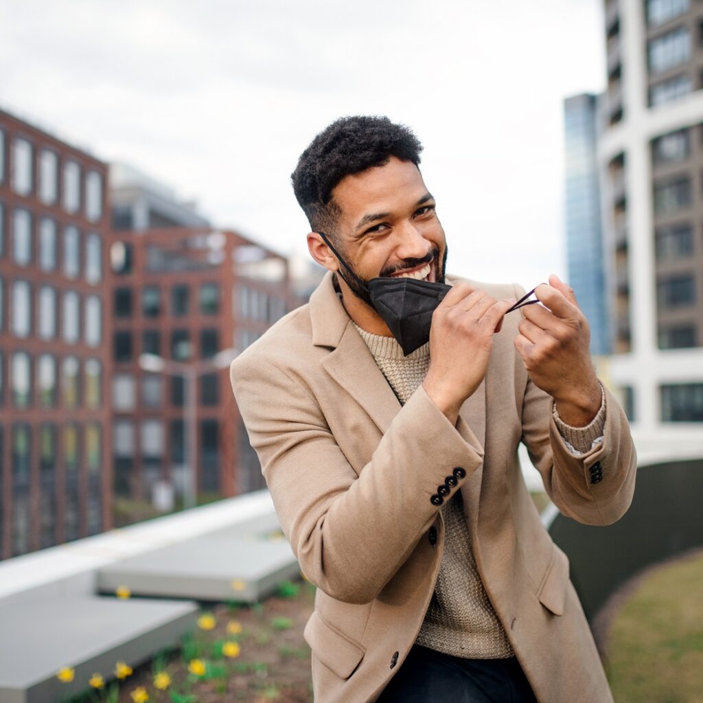 cheerul young man taking off face mask on the way et72pll.jpg